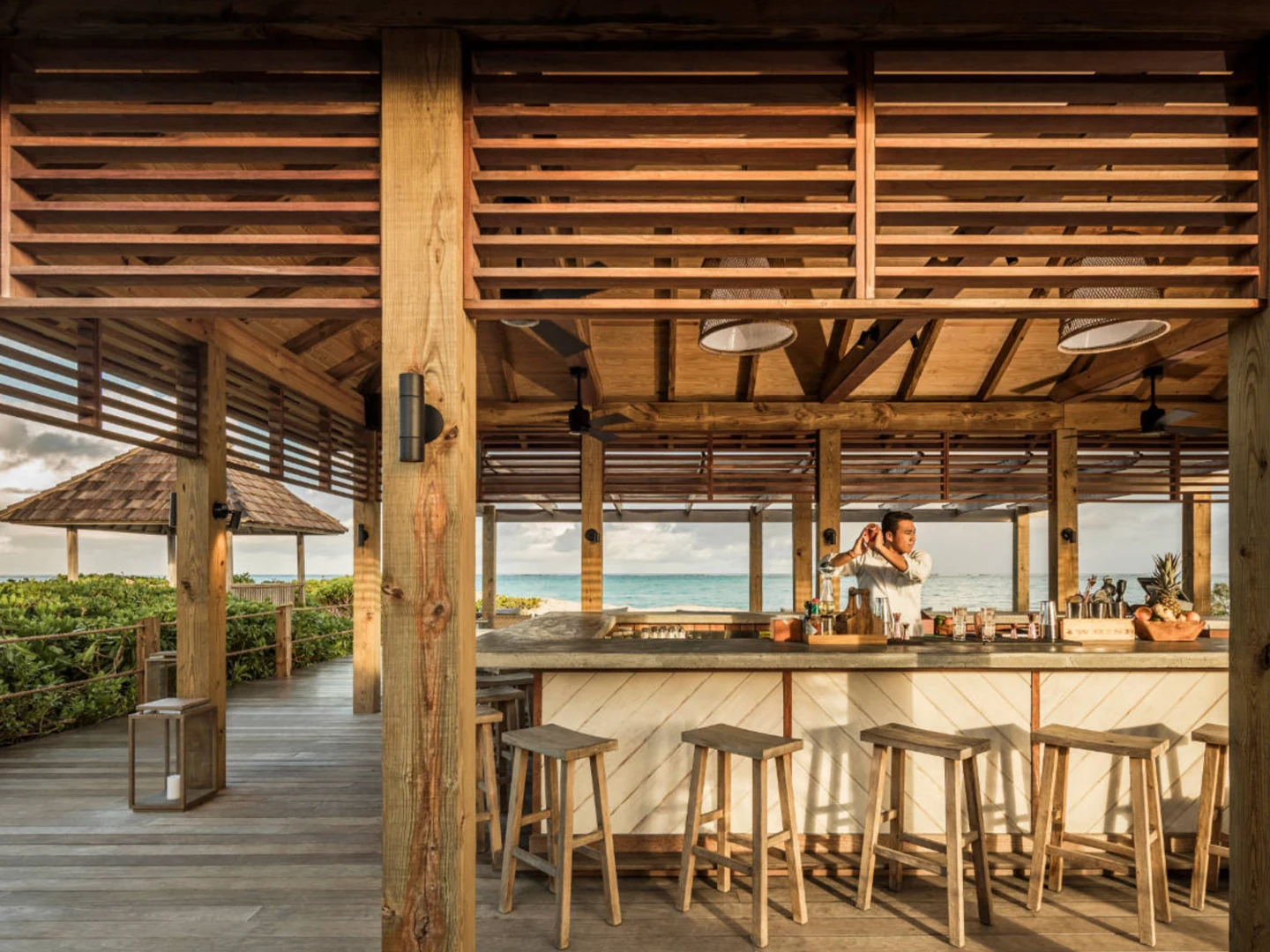 A relaxed oceanfront bar setting expressing Quintessencia hospitality through place, atmosphere and personal service.