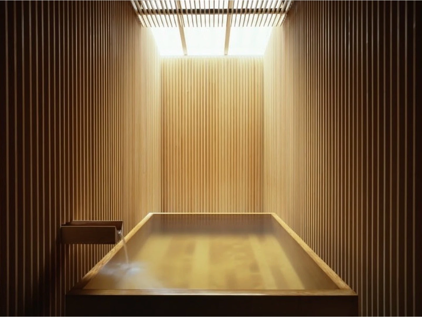 Warm timber-lined hydrotherapy bath at Essence Spa.